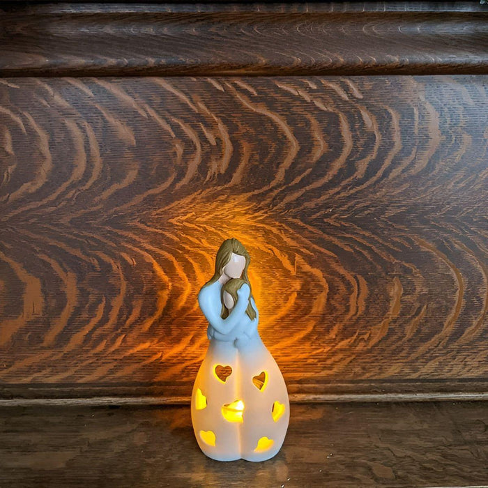 Charmerende mor-datter figur med flimrende lysestage